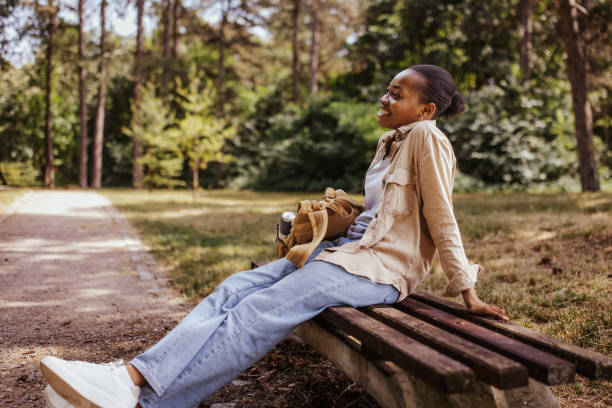 istock Person relaxing on a park bench in nature 2161767665