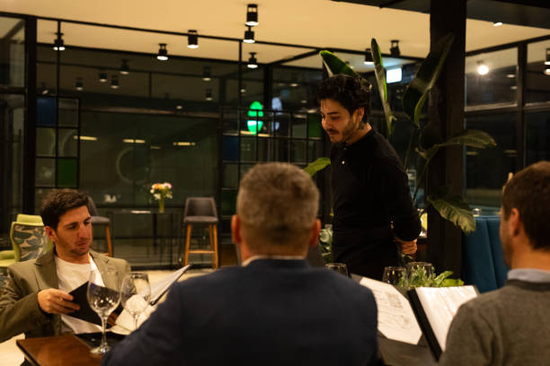 istock Waiter advising three diners about the menu to choose 2161767721