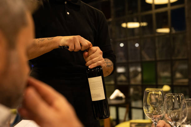 istock Waiter uncorking a bottle of wine to diners 2161767870