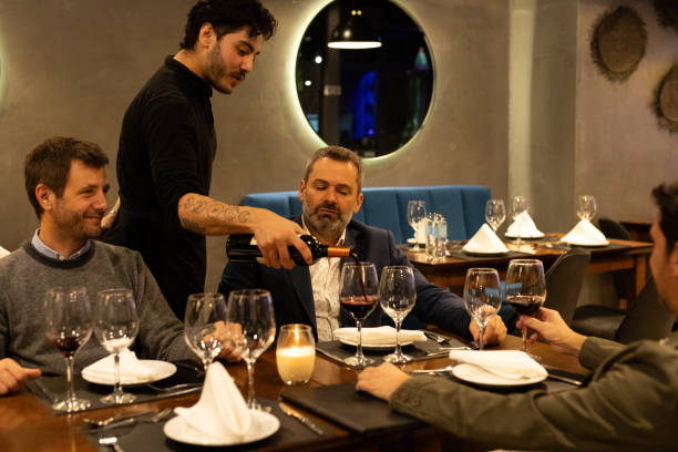 istock Waiter serving wine to male friends diners 2161768003