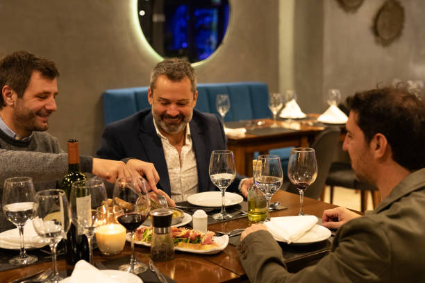 istock Male friends enjoying dinner in a restaurant 2161769094