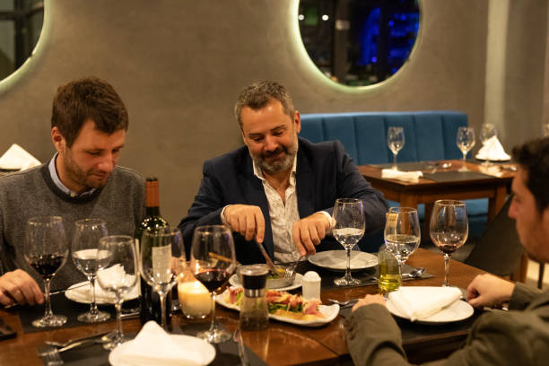 istock Male friends enjoying dinner in a restaurant 2161769104