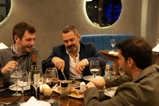 istock Male friends enjoying dinner in a restaurant 2161769111