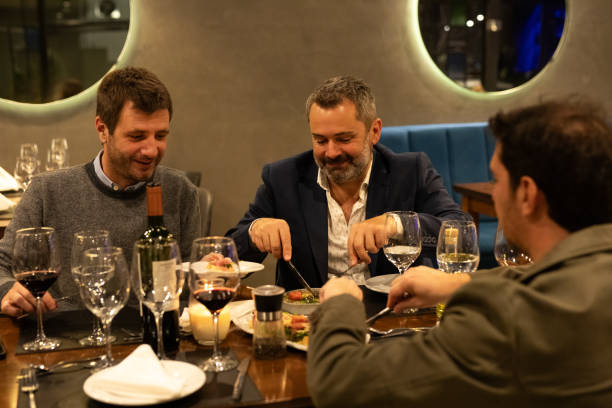 istock Male friends enjoying dinner in a restaurant 2161769155