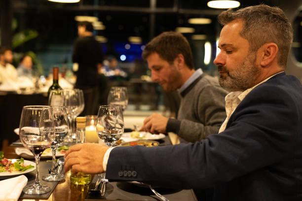 istock Male friends enjoying dinner in a restaurant 2161769255