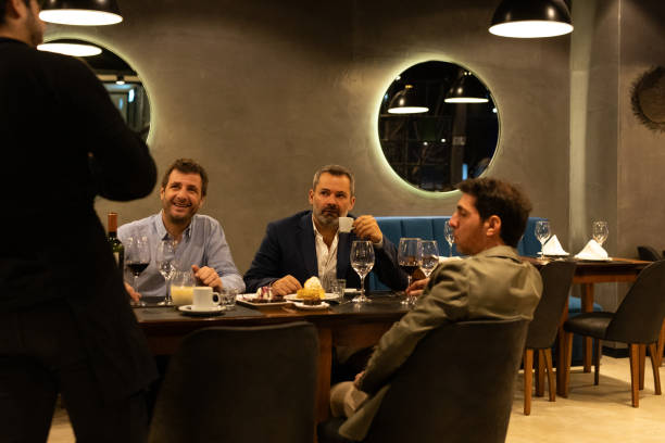 istock Waiter advising three diners about gastronomic options 2161769461