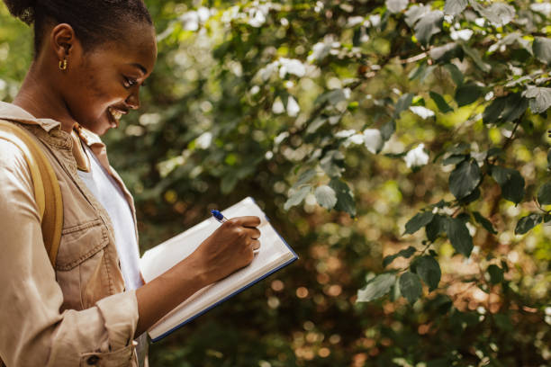 istock Woman writing outdoors amidst natural greenery scene 2161771323