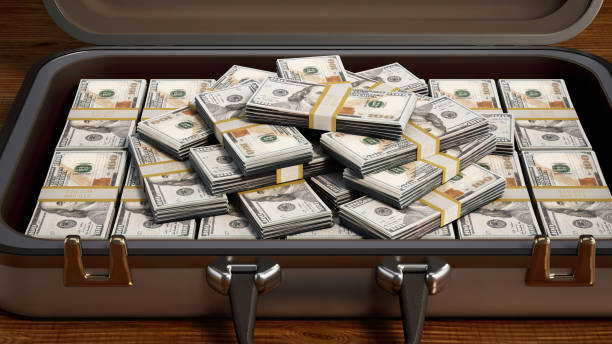 istock Stacks of US Dollar Bills in a Silver Briefcase on a Wood Table. 3D Rendering 2161772529