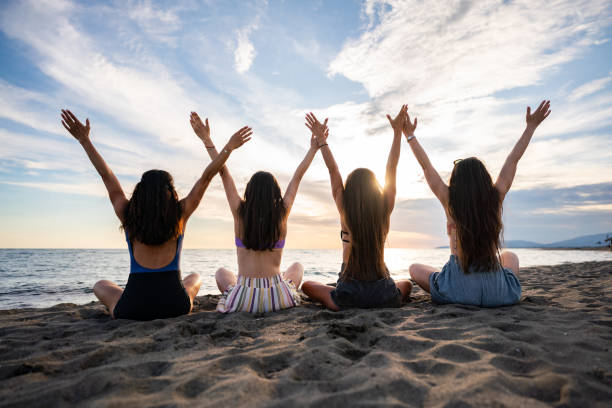 istock Female friends raised their hands during sunset on the beach 2161782692