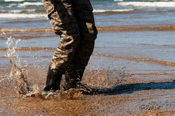 Jumping into the water is a pleasure. Getting into the icy water of the sea with waders can be a solution. Copy Space. Lastres-Colunga(Asturias -Spain)