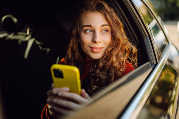 istock Happy young woman using smart phone in car. 2161785710