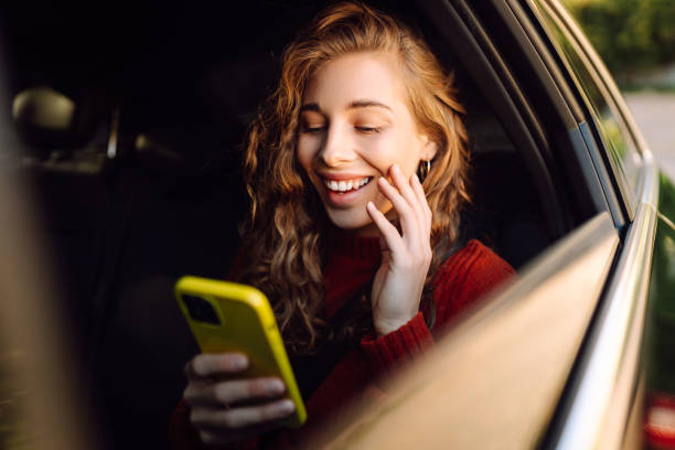 istock Happy young woman using smart phone in car. 2161785712