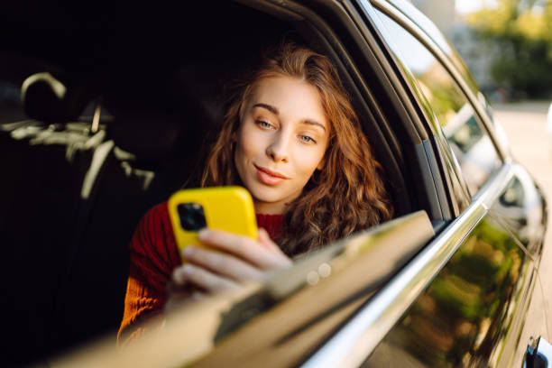 istock Happy young woman using smart phone in car. 2161785718