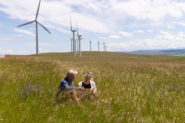 istock Senior couple sit below wind turbines, 2161789868