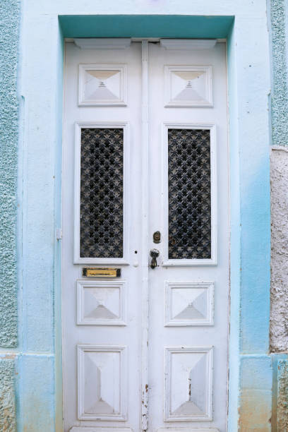 istock Old doorknocker with hand shape on old wooden door 2161796138