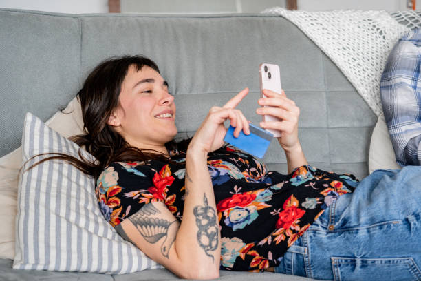 istock Young woman using mobile phone on sofa at home 2161797174