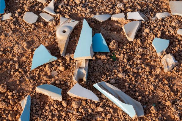 Ceramic light blue and white tiles broken into small sharp pieces, thrown on the volcanic soil in the nature. Lanzarote, Canary Islands, Spain.