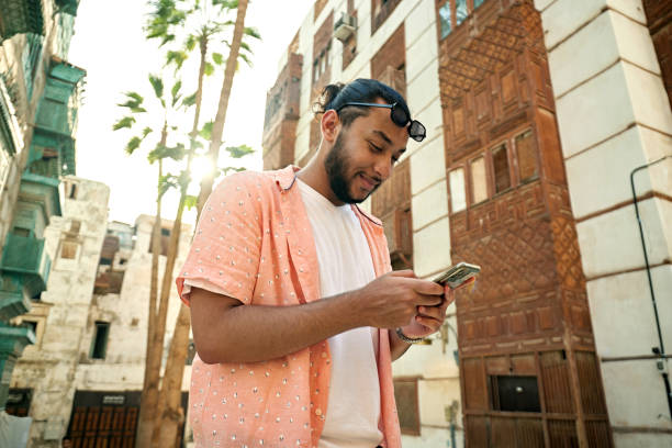 istock Smiling Saudi man in casuals using smart phone 2161801626