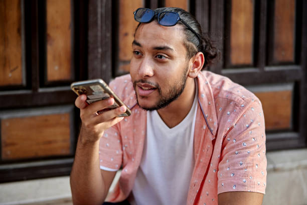 istock Young Saudi man using voice assistant on smart phone 2161801801