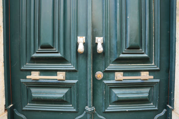 istock Old doorknocker with hand shape on old wooden door 2161802234