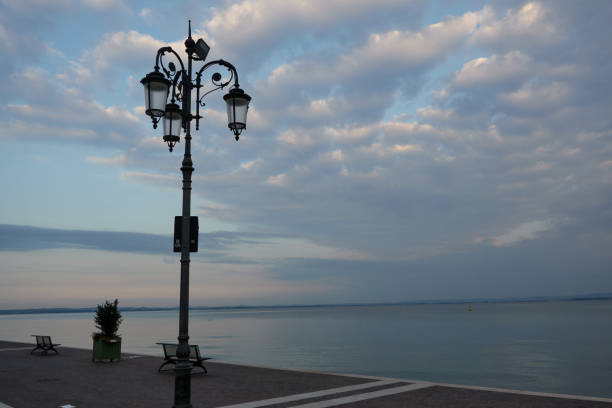 Lazise, Italy - June 15, 2024 - magical morning on Lake Garda. Empty promenade in Lazise