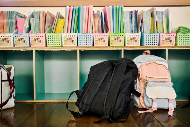 kinderbücher in kisten im klassenzimmer der grundschule angeordnet - schulranzen stock-fotos und bilder