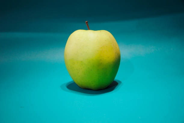 Isolated green apple on bright blue-green background. High quality photo