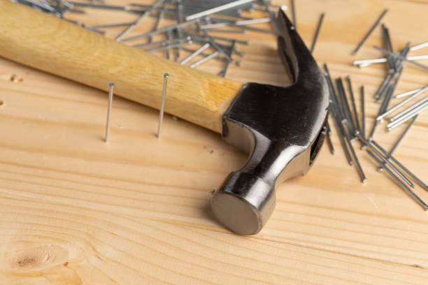istock nails with small caps and an iron hammer on boards 2161807766