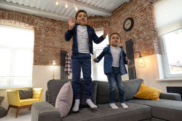 istock Cheerful kids jumping on sofa at home 2161808604