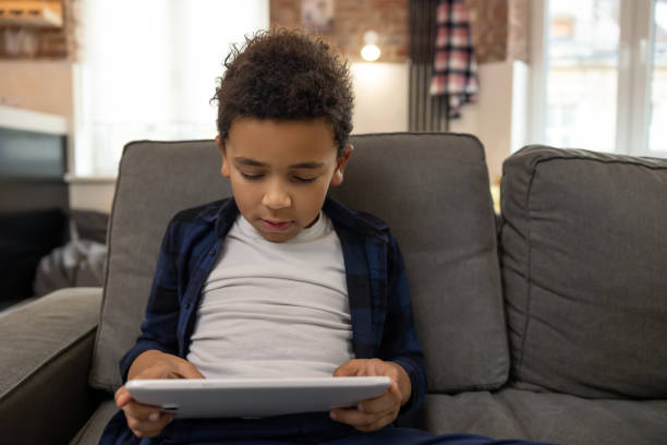 istock Cute boy enjoying playing with digital tablet 2161808638