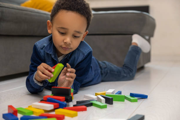 istock Happy cute African American boy playing with multicolored constructor 2161808649