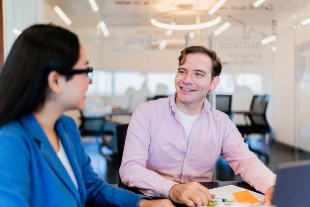 istock Coworkers talking and using laptop at office 2161809696