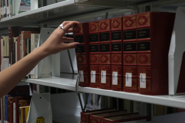 istock A hand examining book pages in a library 2161822009