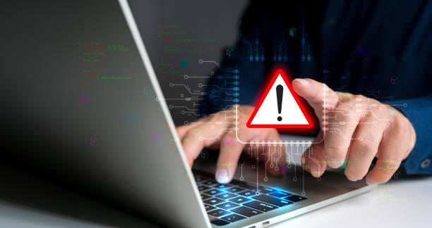 istock System hacked warning alert. Person use laptop with virtual warning sign for cyber attack. 2161826758