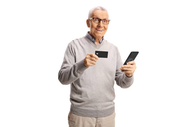 istock Elderly man using a credit card and a mobile phone and smiling at camera 2161826936