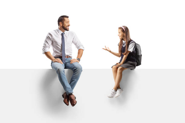 istock Schoolgirl sitting on a panel and talking to a man 2161826959