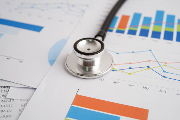 istock Stethoscope and US dollar banknotes on chart or graph paper, Financial, account, statistics and business data  medical health concept. 2161827116