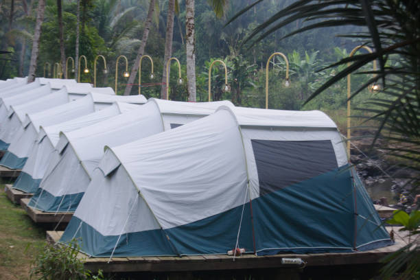 Close-up shot of glamping site with two large white tent with a wooden deck on a lush tropical green garden.concept: Glamping site lush greenery,Luxury tents in tropical garden