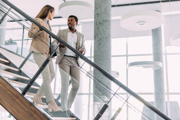 istock Business colleagues talking on stairs in the office. 2161842592