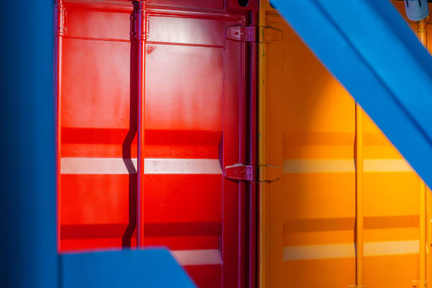 View of warehouse building with various colorful rafters (roof beams) and shipping containers