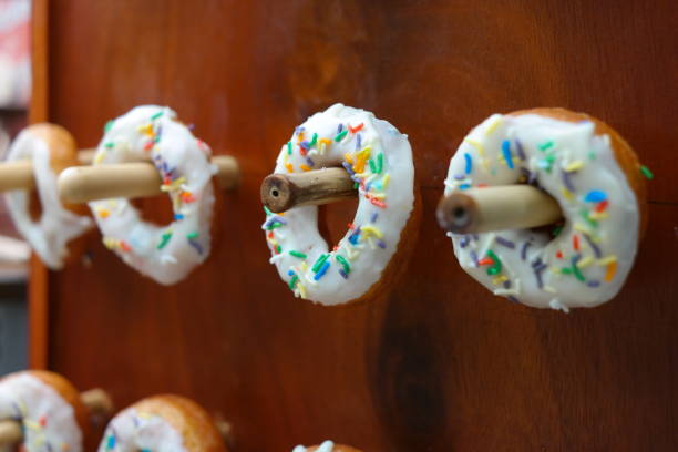 Donuts with colorful sprinkles on a wooden background. Selective focus.