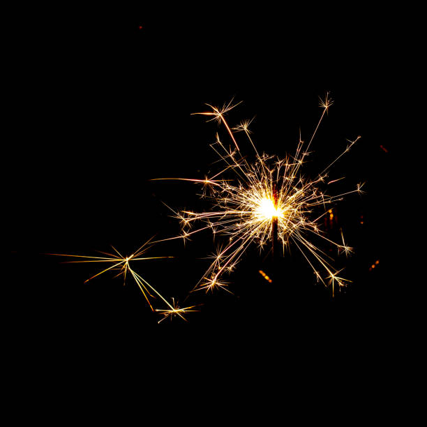 burning sparkler with flying sparks on a dark background close-up