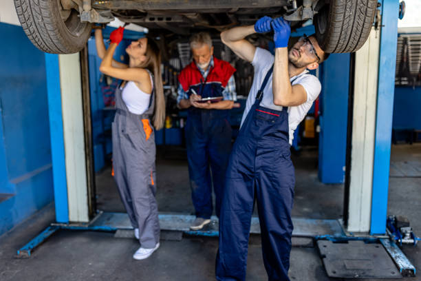 istock An Older Car Mechanic Man and Young Colleagues are Working Underside a Car Using a Mechanic Equipment. 2161853748