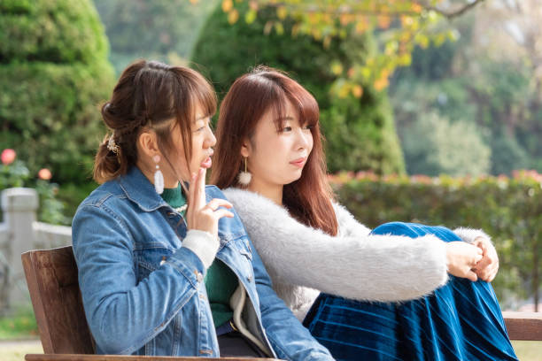 istock Two young Japanese women talking on a bench 2161858942