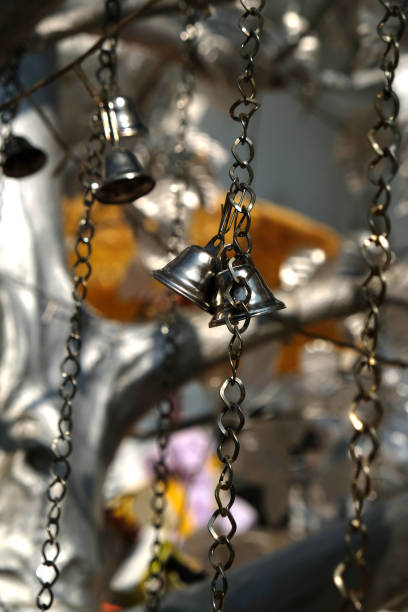 bells on a silver tree near a Buddhist temple