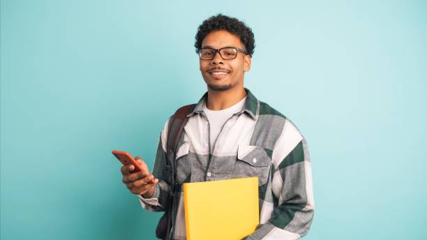 istock Cheerful male student displaying scholarship money in blue studio 2161861100
