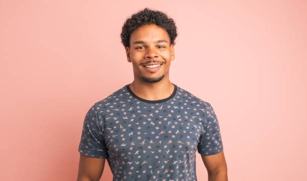 istock Smiling young man looking at camera in pink studio 2161861114