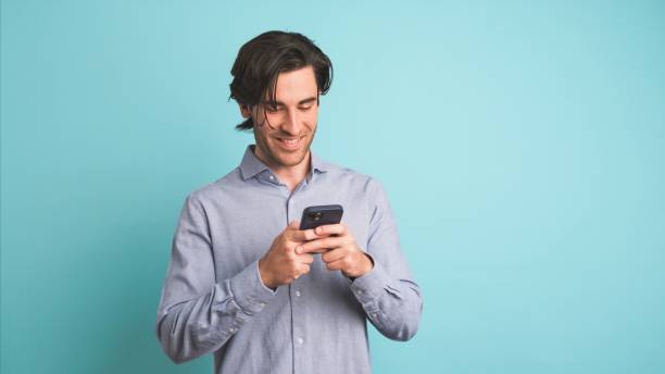 istock Happy adult man using smartphone in blue studio 2161862904