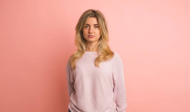 istock Serious young woman thinking in pink studio 2161864600