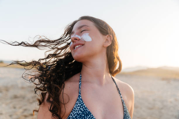 istock Young woman applying sunscreen  at the beach 2161867895